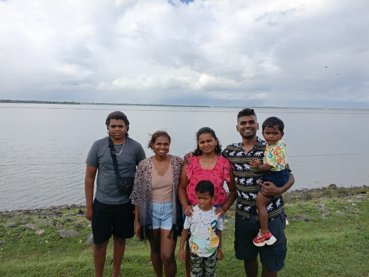 A family with young children beside a large lake