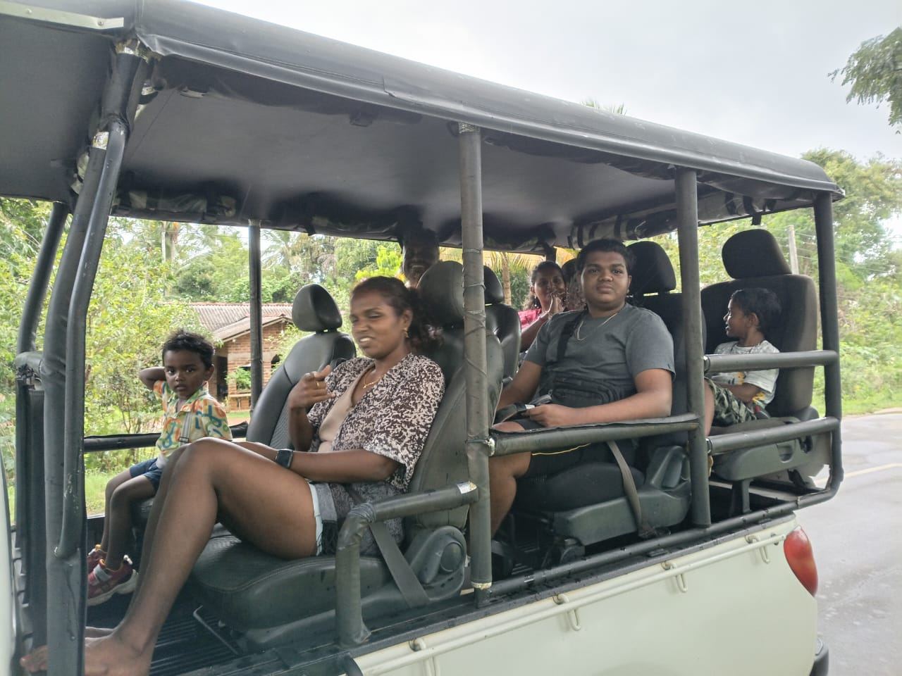 A family with children sitting in an open safari jeep