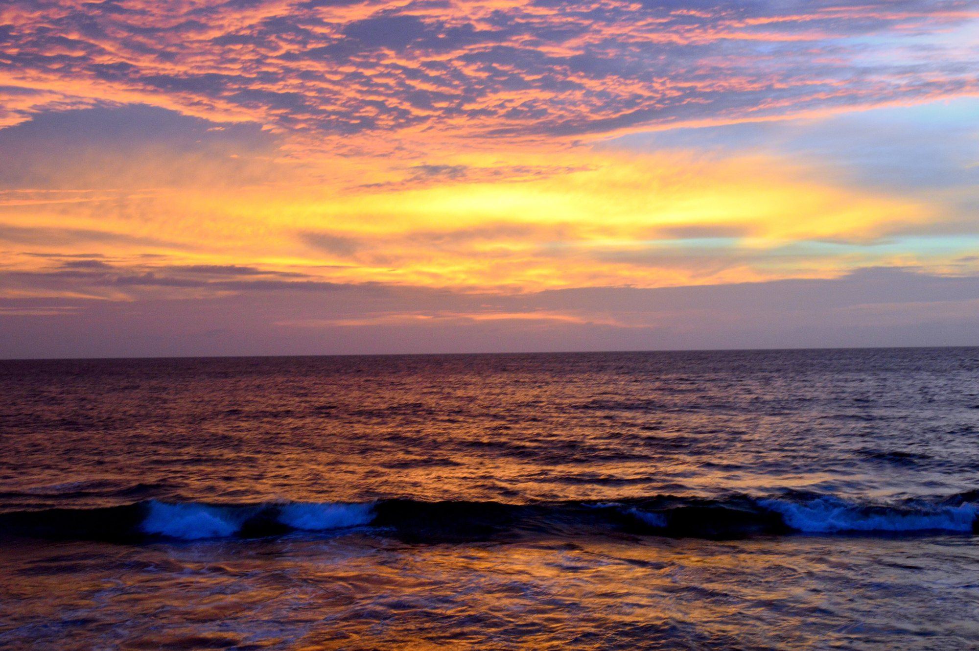 A red and gold sunset over the waves at Galle Face Green in Colombo