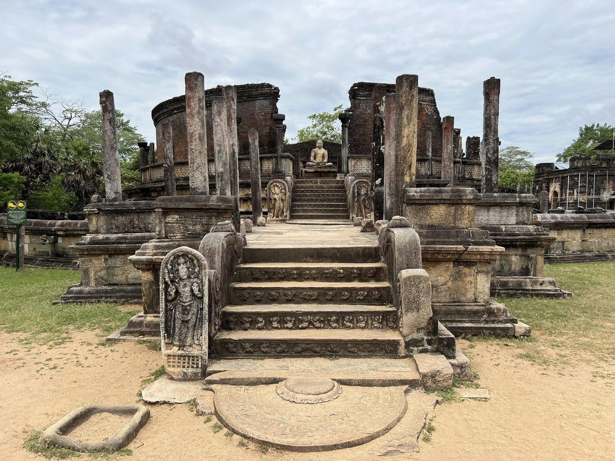 Stone steps and a seated Buddha at the Vatadage in Polonnaruwa